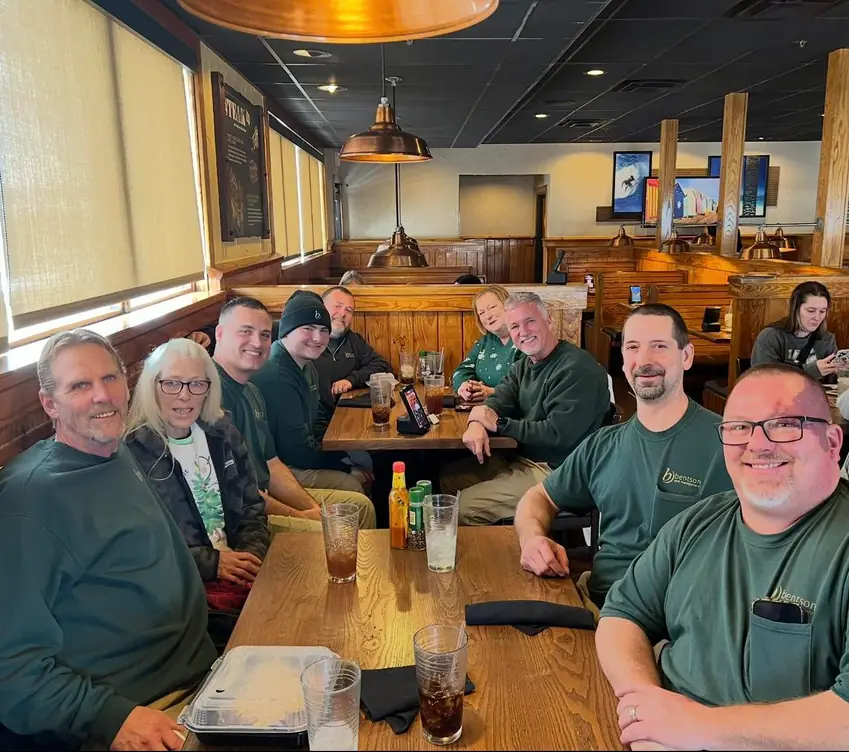 Bentson Pest Management staff at a team gathering, several wearing green Bentson branded shirts
